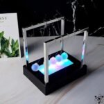 pendule de newton lumineux eblouissant pour decoration socle noir 629 1
